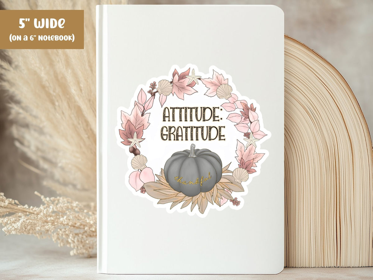 "Attitude: Gratitude" thankful sticker, 5-inch size, on the cover of a white 6-inch notebook