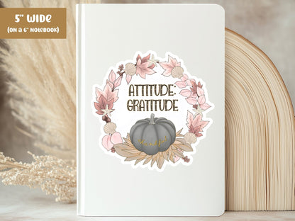 "Attitude: Gratitude" thankful sticker, 5-inch size, on the cover of a white 6-inch notebook