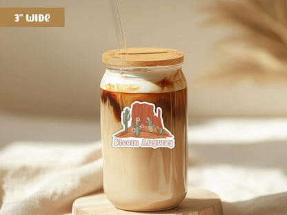 "Bloom Anyway" flower sticker, 3-inch size, on a glass iced coffee cup with a bamboo lid