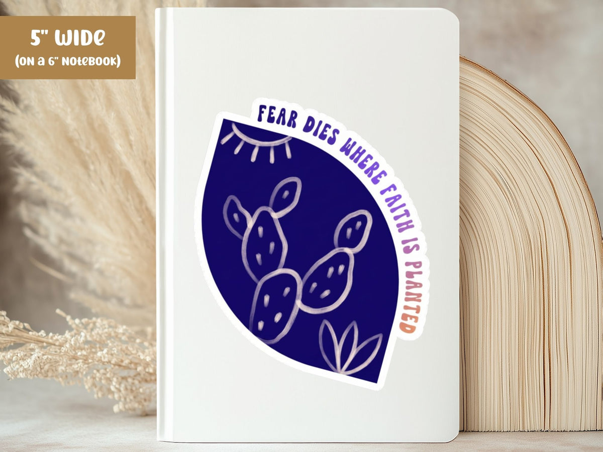 "Fear Dies Where Faith Is Planted" fearless sticker, 5-inch size, on the cover of a white 6-inch notebook