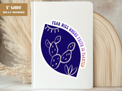 "Fear Dies Where Faith Is Planted" fearless sticker, 5-inch size, on the cover of a white 6-inch notebook