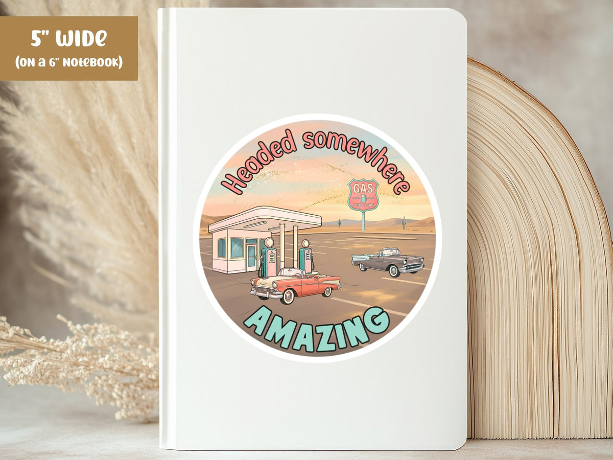 "Headed Somewhere Amazing" retro road trip sticker, 5-inch size, on the cover of a white 6-inch notebook
