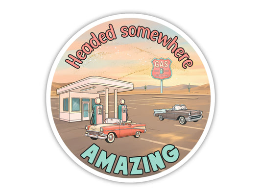 "Headed Somewhere Amazing" retro road trip sticker. Two classic convertibles at a pastel vintage gas station at sunrise, with a GAS sign and a saguaro in the distance