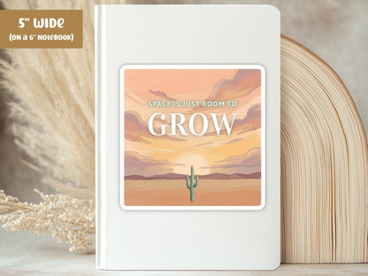 "Space Is Just Room to Grow" desert cactus sticker, 5-inch size, on the cover of a white 6-inch notebook